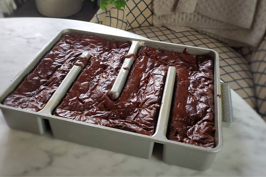 Baker's Edge edge pan for brownies listed as a great romantic gift to give your wife. Pictured is the brownie pan with a chocolate brownie baked in it with perfect edges.